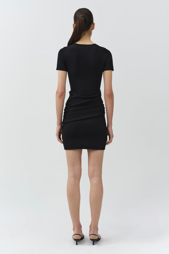 Black knit mini dress with short sleeves and ruched side detailing on the skirt, shown on model from back.