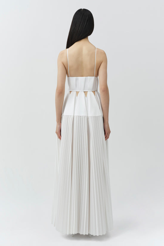 White sleeveless gown with pleated skirt, cutout details at waist, and thin shoulder straps, shown from back.