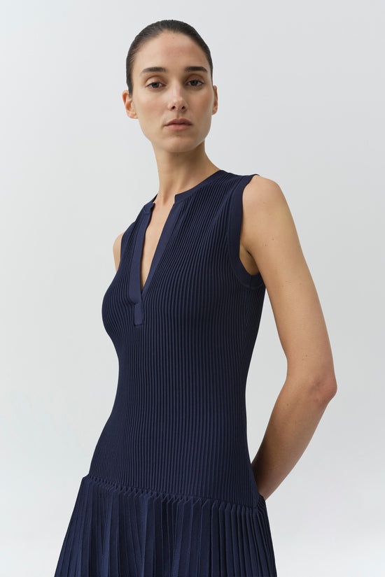 Navy ribbed knit sleeveless dress with V-neckline and pleated drop waist skirt.