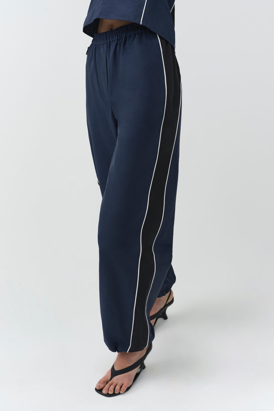 Navy cotton faille jogger with white piping detail on the sides and elasticized waistband.