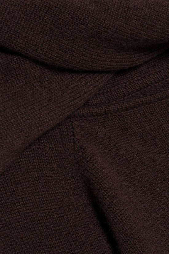 Dark brown knit fabric with textured weave and draped folds showing the garment's structure.