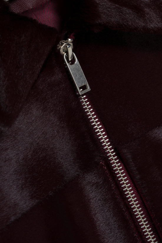 Dark burgundy calf hair jacket with silver metal zipper and pull detail.