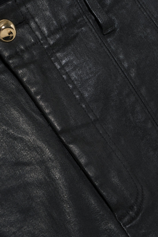 Black coated denim trouser with textured surface and gold button detail.