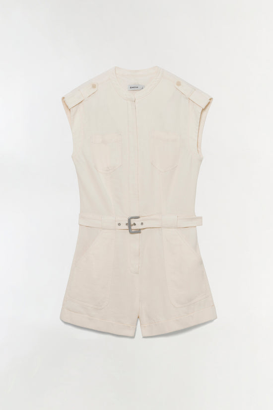 Cream linen romper with button-front closure, chest pockets, shoulder tabs, and matching belt with buckle.