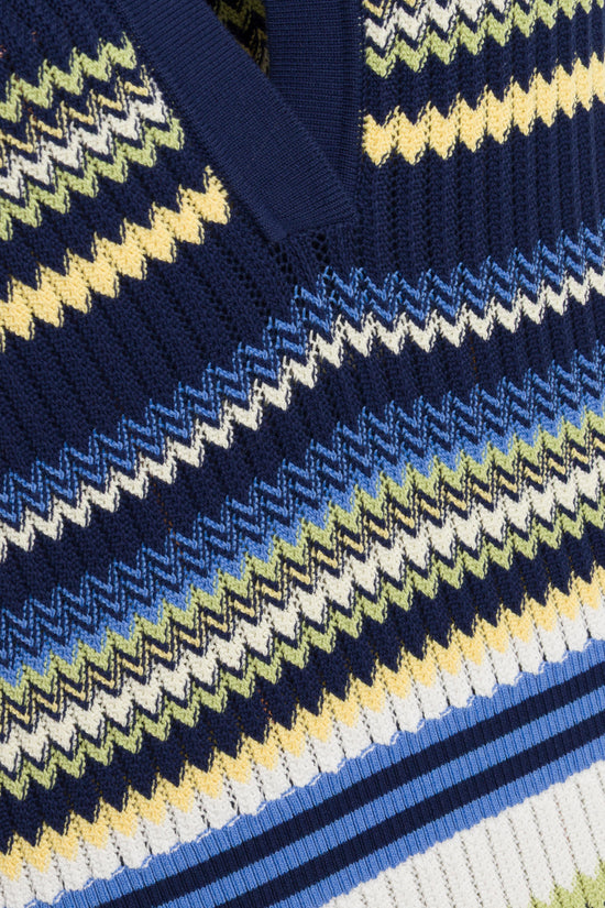 Navy knit fabric with geometric houndstooth pattern in yellow, blue, white and green stripes.