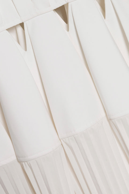 White cotton gown with vertical pleats throughout and pleated hem detail at bottom.