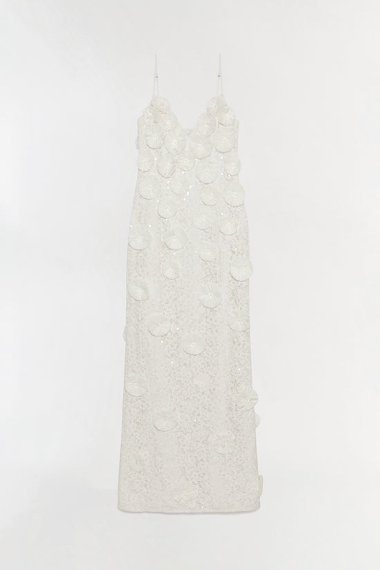 Cream sleeveless gown with textured base and layered circular raffia appliqués across bodice and skirt, thin shoulder straps.