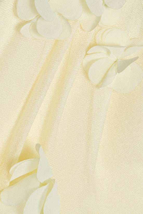 Cream-colored knit fabric with three-dimensional white petal appliques scattered across the surface.