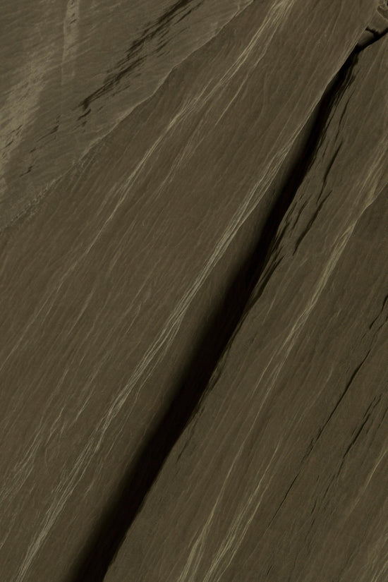 Olive-green striped fabric with vertical texture and fold detail.