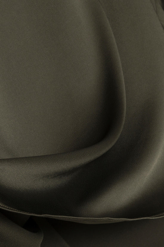 Sage green satin fabric with draped folds showing smooth texture and sheen.