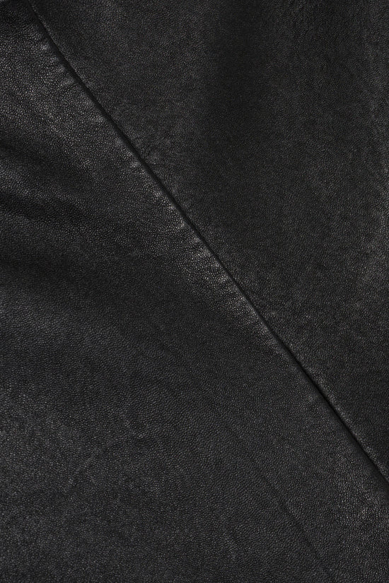Black leather fabric with diagonal seam detail and textured surface.