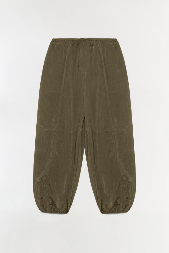 Olive-green parachute pants with a drawstring waist, tapered ankles, and textured fabric.