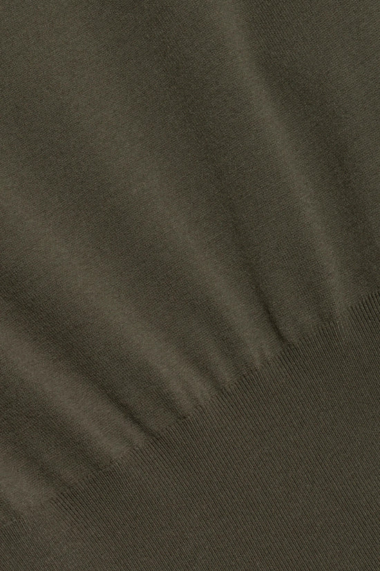 Olive green knit fabric with textured weave and ribbed trim visible at the edge.