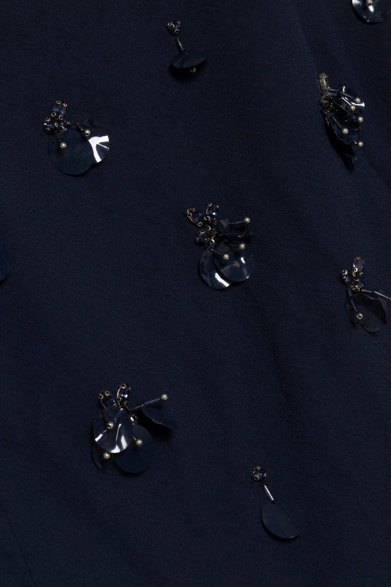 Navy crepe fabric with scattered embellished embroidered details featuring dark beads and metallic accents.