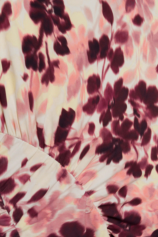 Draped jersey fabric with burgundy and pink floral print on cream background, showing halter neckline gathering.