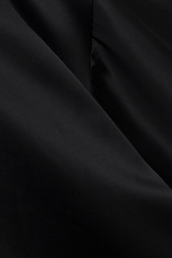 Black satin fabric with draped folds showing lustrous sheen and texture detail.