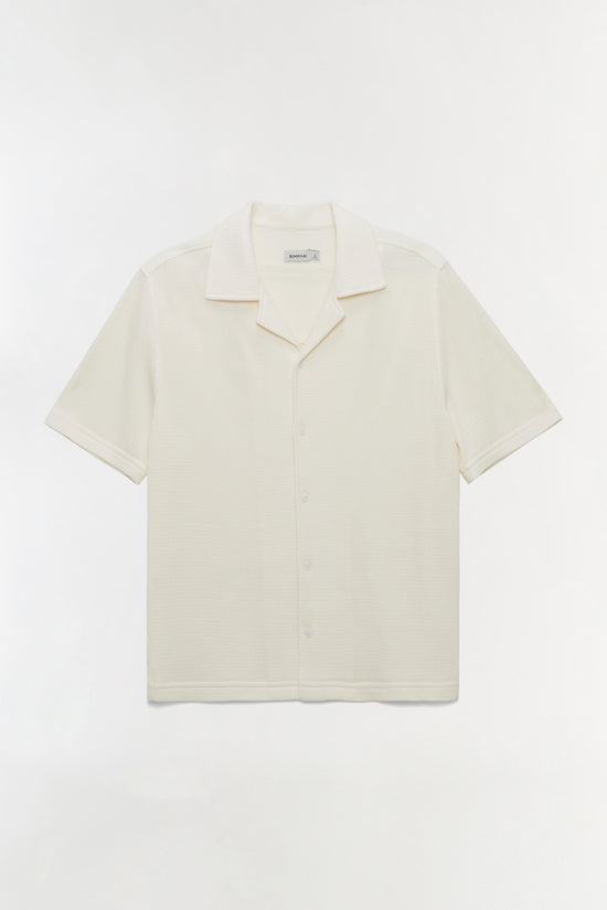 Cream short-sleeve waffle-knit shirt with notched collar and button front closure.