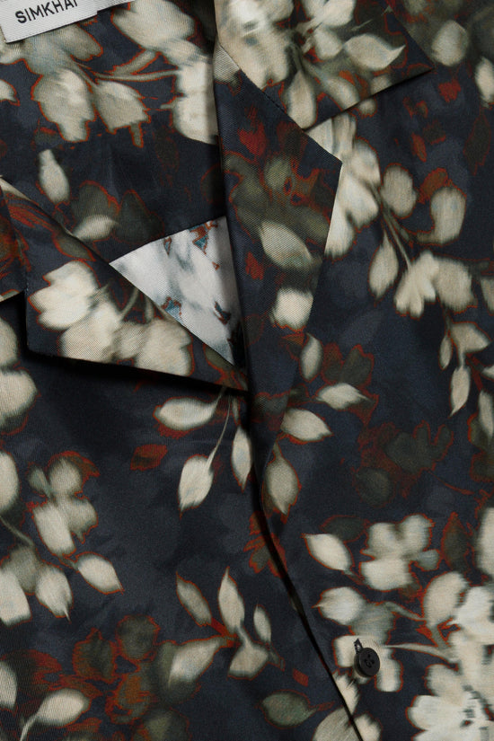 Navy silk shirt with white and red floral print, button front closure, and folded collar detail.