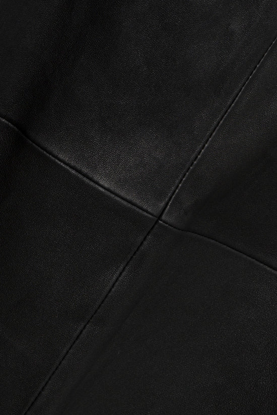 Black leather skirt with seamed paneling detail and fitted silhouette.