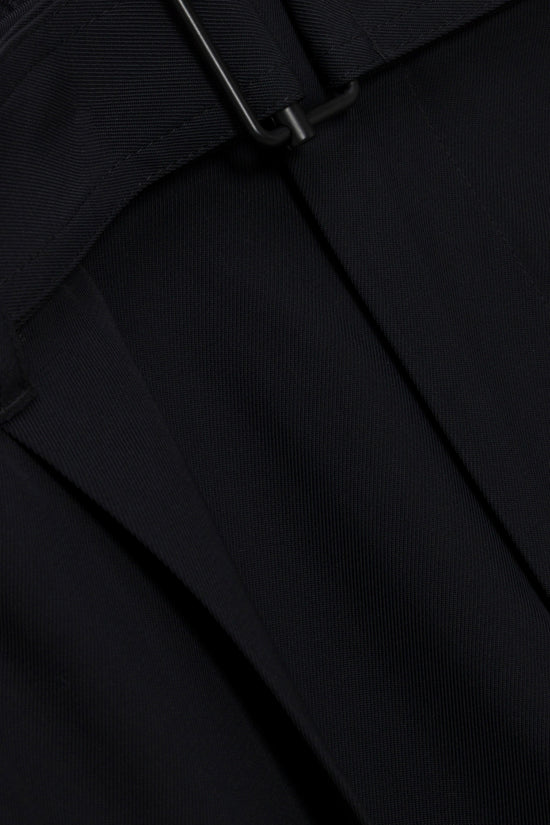 Black ribbed trousers with a side zipper detail and draped fabric folds.