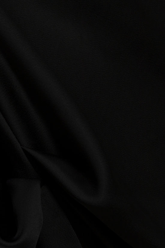 Black satin cape top with draped fabric detail on the shoulder and side.