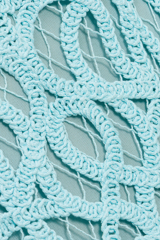 Light blue lace with scrolled pattern details and sheer mesh base fabric.