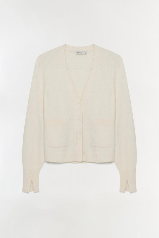 Cream knit cardigan with V-neckline, button front closure, chest pockets, and ribbed cuffs.