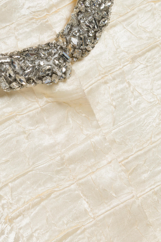 Cream satin fabric with silver beaded embellishment along the neckline detail.