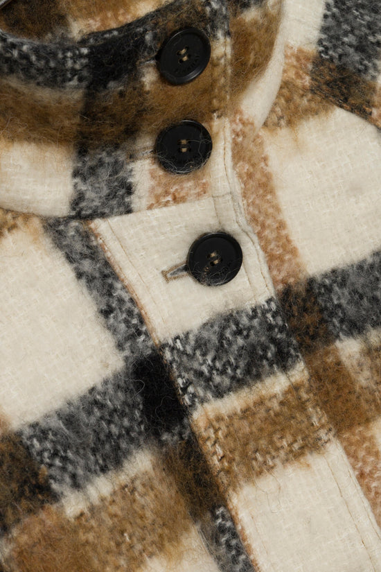 Plaid jacket front detail showing brown, cream, and black plaid pattern with black buttons.