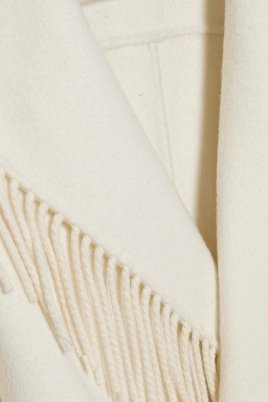 Cream-colored jacket with fringe trim along the hem and an open front.