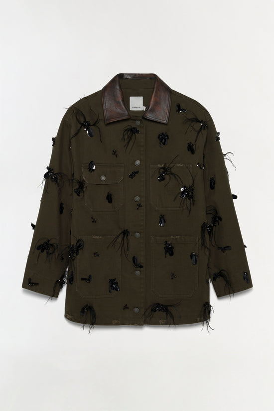 Olive-green denim jacket with dark leather collar and black beaded embellishments scattered across front and sleeves.