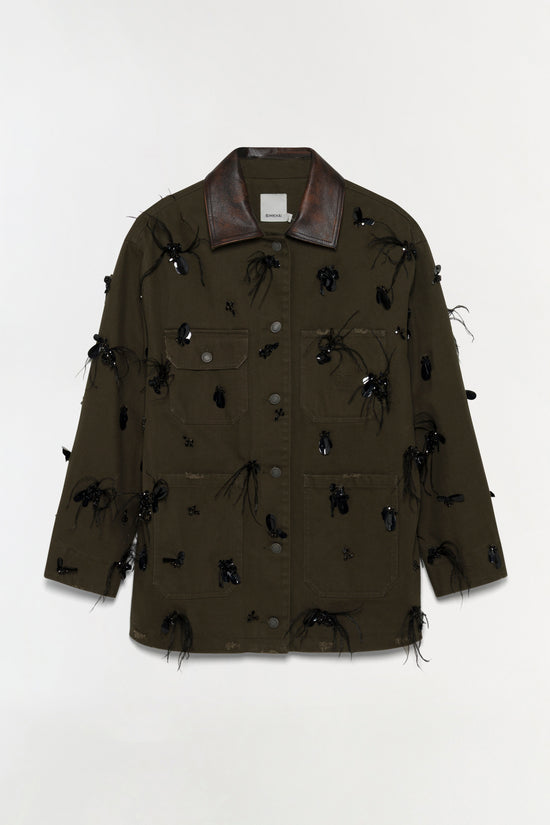 Olive-green denim jacket with dark leather collar and black beaded embellishments scattered across front and sleeves.