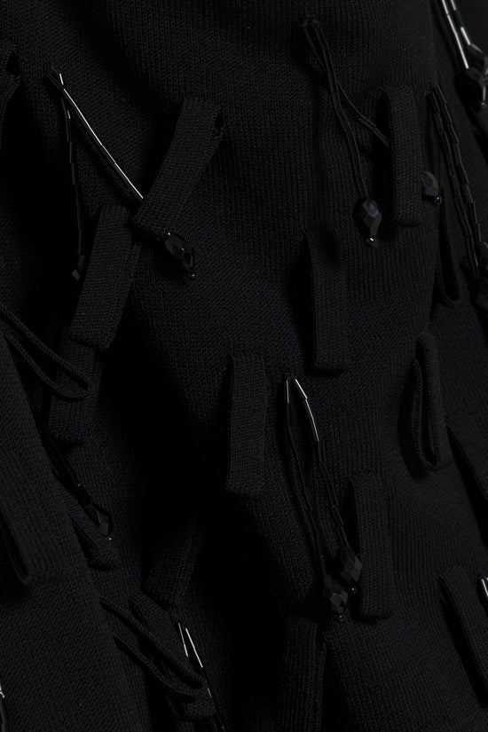 Black knit midi skirt with metallic and bead embellishments scattered throughout the fabric.
