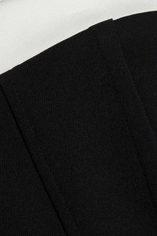 Black knit midi dress with textured fabric detail against neutral background.