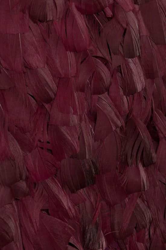 Burgundy feathered gown with layered feather texture in varying shades of wine and plum.