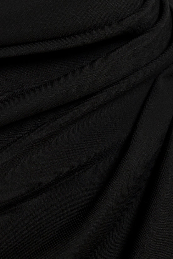 Black ribbed fabric with soft draped folds and textured surface detail.