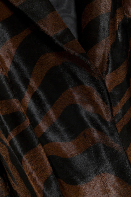 Brown and black calf hair with geometric color-block pattern and draped fabric detail.