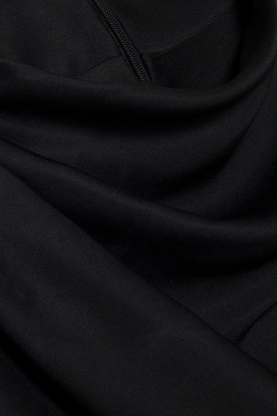 Black satin gown with draped fabric and center front zipper detail.