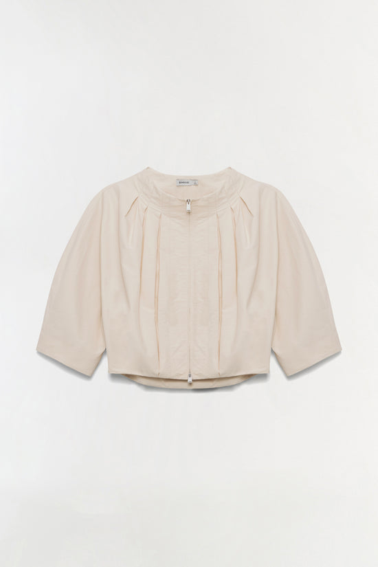 Cream-colored pleated jacket with three-quarter sleeves, round neckline, and front zip closure.
