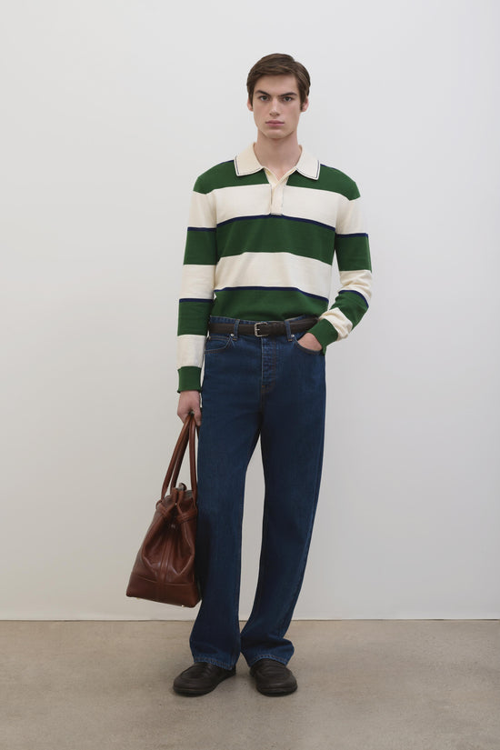 Green and cream striped long-sleeve popover with collar, worn with dark jeans and brown leather bag.