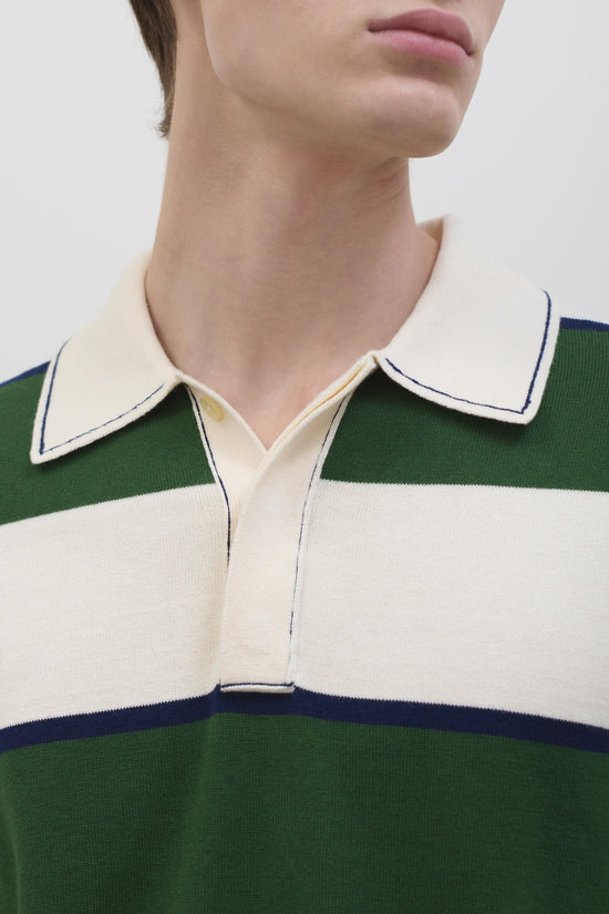 Cream, green, and navy striped popover with white-trimmed collar and half-zip front on model.
