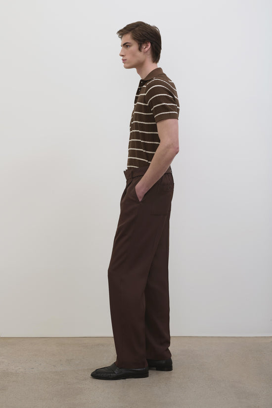 Man wearing brown striped polo shirt with short sleeves and dark brown trousers.