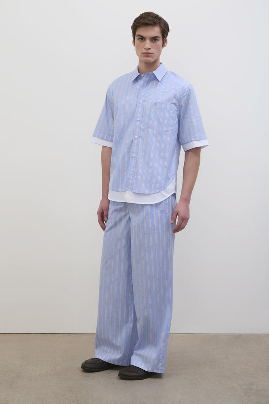 Man wearing light blue striped short-sleeve cotton shirt with white collar and matching striped pants.
