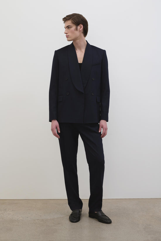 Black straight-leg trousers styled with a double-breasted blazer and black shoes.