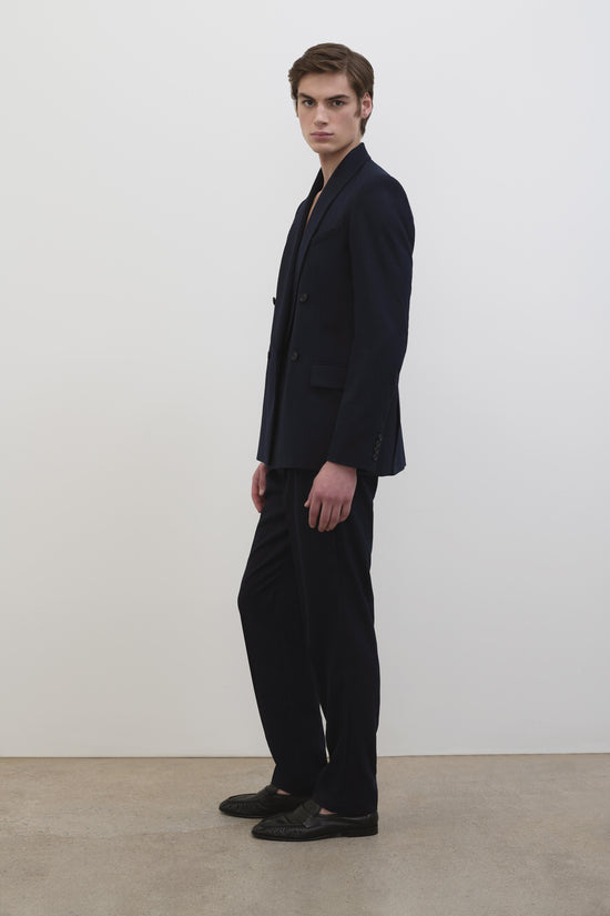 Black trousers with high waistband and wide straight-leg silhouette, worn with matching blazer.