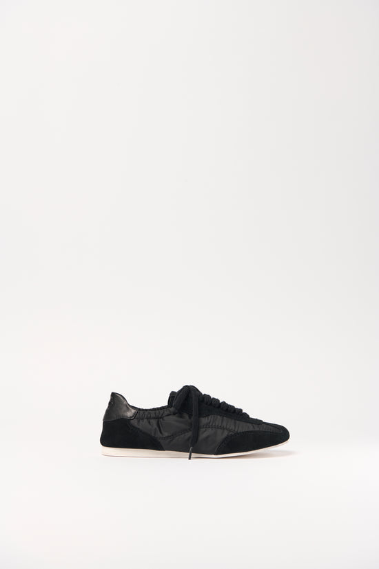 Black nylon and suede sneaker with lace-up closure and cream-colored sole, shown in profile view.