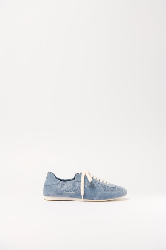 Blue denim sneaker with cream laces and white sole, shown in side profile view.