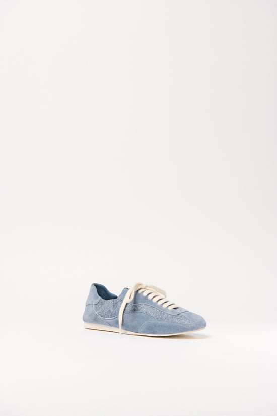 Blue denim and leather lace-up sneaker with cream-colored sole and heel counter, shown in side profile.