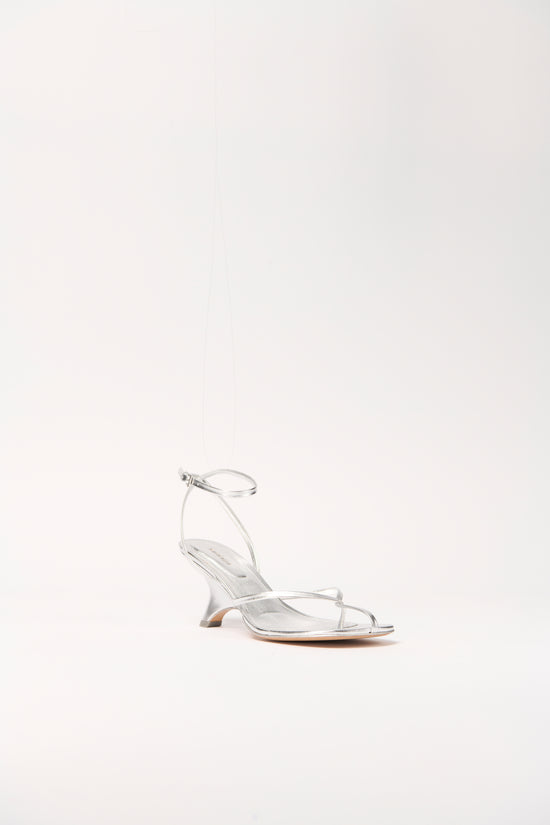 Silver leather strappy wedge sandal with ankle buckle closure and wedge heel.