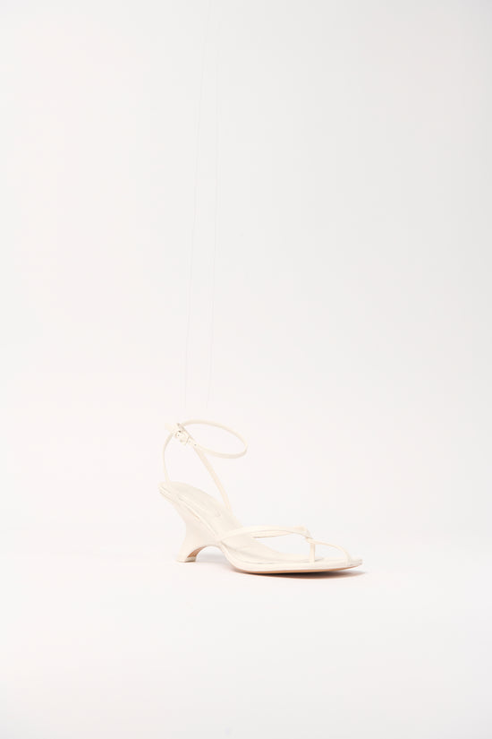 Cream leather strappy wedge sandal with ankle strap and open toe design.